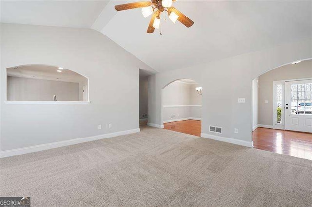 85 Stiles Dr, Dallas, GA 30132 - unfurnished living room with arched walkways, carpet, a ceiling fan, and vaulted ceiling