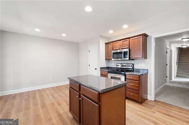 85 Stiles Dr, Dallas, GA 30132 - kitchen featuring appliances with stainless steel finishes, a center island, light wood-style floors, brown cabinetry, and recessed lighting