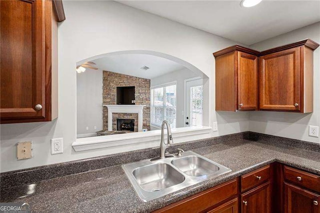 85 Stiles Dr, Dallas, GA 30132 - kitchen featuring dark countertops, lofted ceiling, arched walkways, a fireplace, and open floor plan