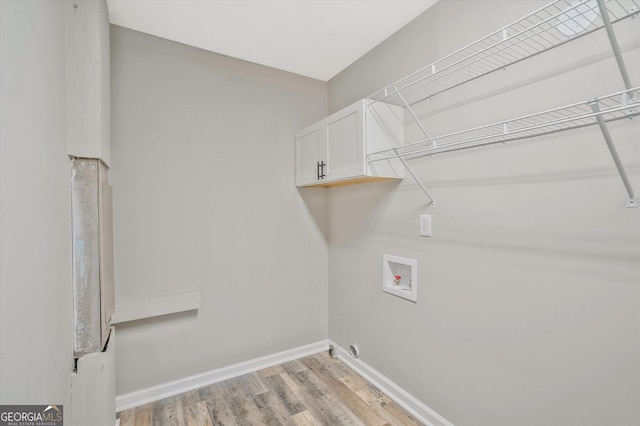 3290 Ebenezer Rd SE, Conyers, GA 30094 - laundry area with cabinet space, hookup for a washing machine, light wood-style flooring, and baseboards