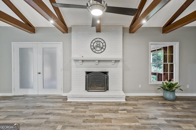 3290 Ebenezer Rd SE, Conyers, GA 30094 - unfurnished living room featuring wood finished floors, baseboards, a fireplace, and french doors