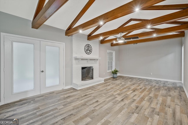3290 Ebenezer Rd SE, Conyers, GA 30094 - unfurnished living room featuring french doors, beamed ceiling, baseboards, light wood-style floors, and high vaulted ceiling