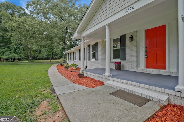 3290 Ebenezer Rd SE, Conyers, GA 30094 - doorway to property with covered porch, brick siding, and a lawn