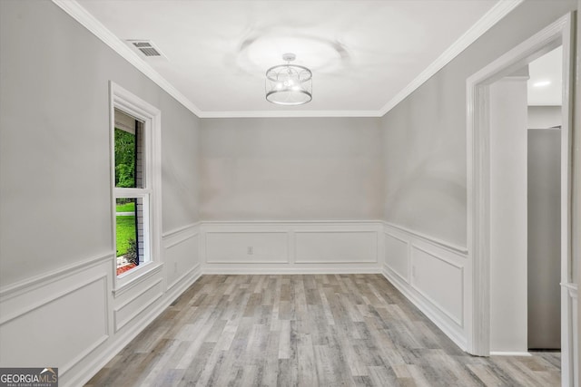 3290 Ebenezer Rd SE, Conyers, GA 30094 - unfurnished dining area with light wood finished floors, crown molding, a wainscoted wall, a chandelier, and a decorative wall