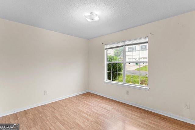 3599 Salem Glen Rd, Lithonia, GA 30038 - empty room with light wood-style floors, baseboards, and a textured ceiling