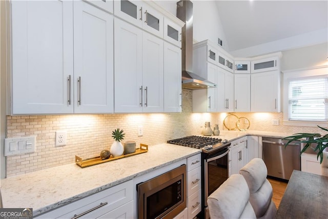 151 Savannah St SE, Atlanta, GA 30316 - kitchen with appliances with stainless steel finishes, wall chimney range hood, vaulted ceiling, white cabinets, and decorative backsplash
