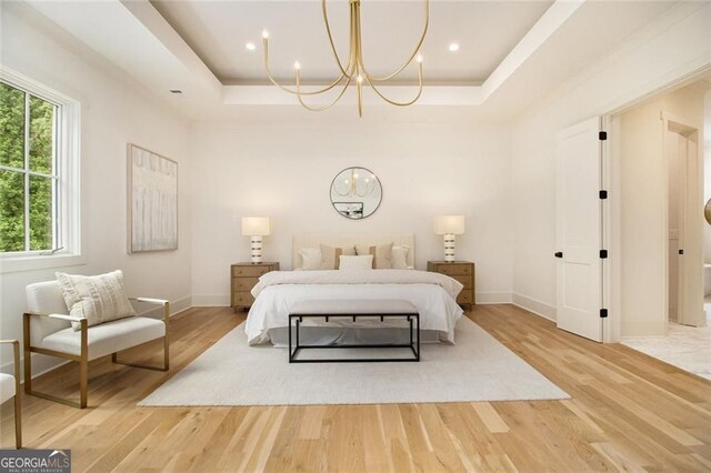 4757 Lake Forrest Dr NW, Atlanta, GA 30342 - bedroom with a chandelier, a tray ceiling, light wood-style flooring, and baseboards