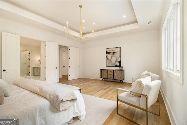 4757 Lake Forrest Dr NW, Atlanta, GA 30342 - bedroom featuring light wood-type flooring, a chandelier, baseboards, a raised ceiling, and connected bathroom