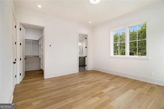 4757 Lake Forrest Dr NW, Atlanta, GA 30342 - unfurnished bedroom featuring light wood finished floors, a spacious closet, baseboards, and recessed lighting