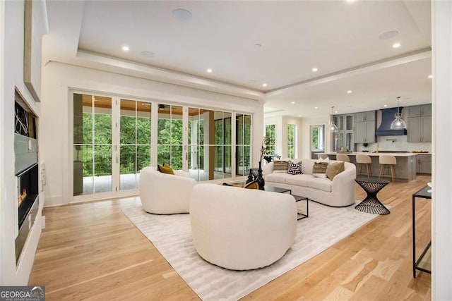 4757 Lake Forrest Dr NW, Atlanta, GA 30342 - living area with light wood-style flooring, a raised ceiling, a glass covered fireplace, and recessed lighting