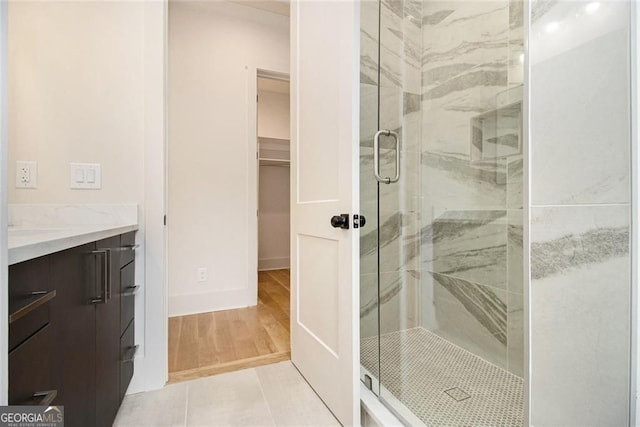 4757 Lake Forrest Dr NW, Atlanta, GA 30342 - bathroom with a shower stall, vanity, a spacious closet, and wood finished floors