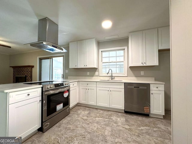 120 Watson Dr, Athens, GA 30605 - kitchen featuring appliances with stainless steel finishes, island exhaust hood, a sink, a peninsula, and white cabinets