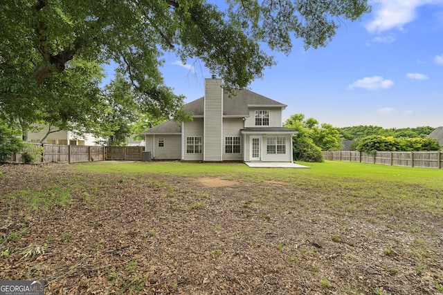 2881 Bridle Creek Dr SW, Conyers, GA 30094 - back of property with a patio area, a fenced backyard, and a chimney