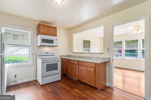 2329 Polar Rock Ave SW, Atlanta, GA 30315 - kitchen featuring white appliances, brown cabinets, dark wood-style flooring, and plenty of natural light