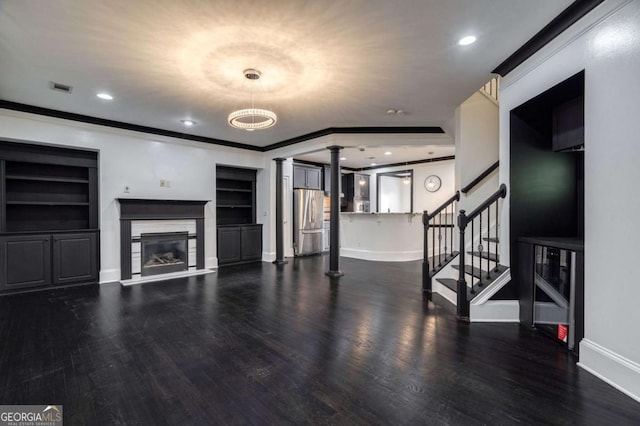2767 Durham Dr NE, Atlanta, GA 30319 - unfurnished living room with ornate columns, wood finished floors, stairway, ornamental molding, and a glass covered fireplace