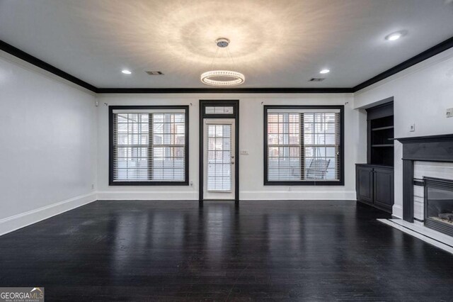 2767 Durham Dr NE, Atlanta, GA 30319 - unfurnished living room with crown molding, wood finished floors, a glass covered fireplace, baseboards, and built in shelves