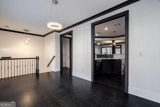 2767 Durham Dr NE, Atlanta, GA 30319 - empty room with dark wood-type flooring, ornamental molding, baseboards, and a sink