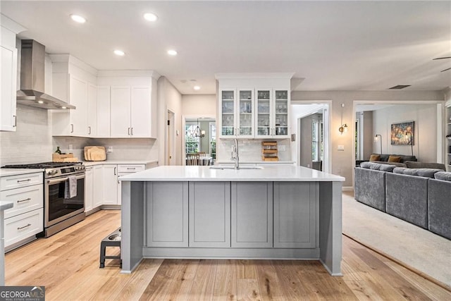 525 Arbor Creek Ct, Roswell, GA 30076 - kitchen featuring stainless steel gas range oven, wall chimney range hood, a sink, light countertops, and white cabinetry