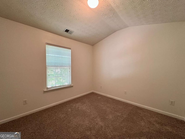 234 Silver Arrow Cir, Austell, GA 30168 - spare room featuring lofted ceiling, dark carpet, baseboards, and a textured ceiling