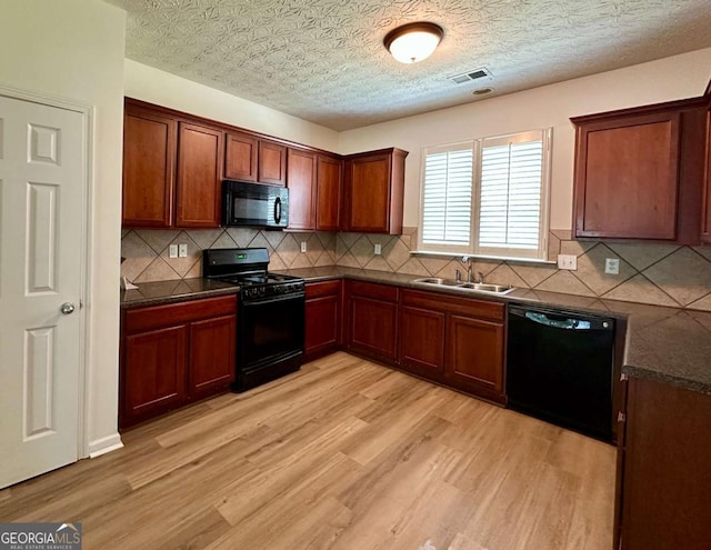 234 Silver Arrow Cir, Austell, GA 30168 - kitchen with black appliances, a sink, dark countertops, and light wood-style flooring
