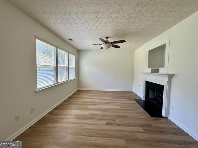 234 Silver Arrow Cir, Austell, GA 30168 - unfurnished living room with a ceiling fan, wood finished floors, a fireplace with flush hearth, and baseboards