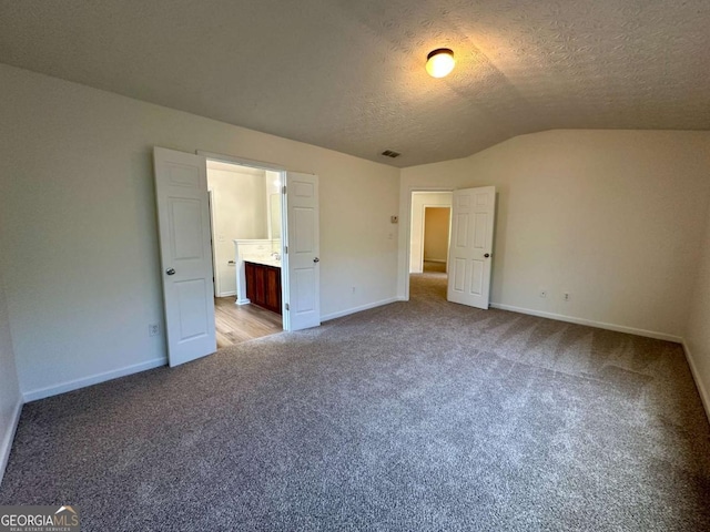 234 Silver Arrow Cir, Austell, GA 30168 - unfurnished bedroom with lofted ceiling, carpet floors, baseboards, a textured ceiling, and ensuite bath