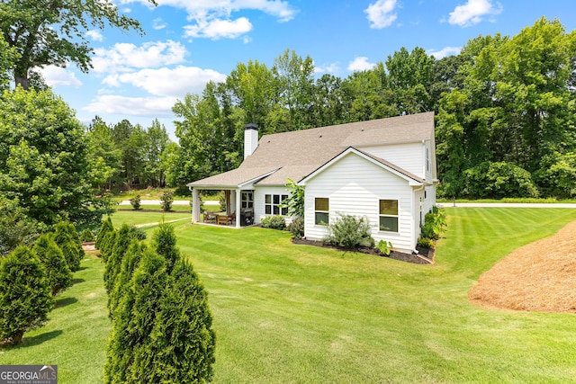 19 E Murphy St, Newnan, GA 30263 - back of property featuring a lawn, a chimney, a patio area, and a shingled roof