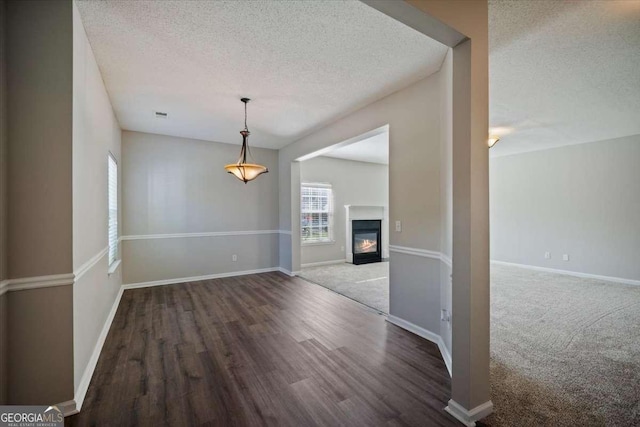 3223 Tallon Ln SW, Atlanta, GA 30311 - unfurnished dining area with a textured ceiling, wood finished floors, baseboards, and a glass covered fireplace