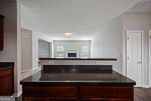 3223 Tallon Ln SW, Atlanta, GA 30311 - kitchen with a kitchen island, a textured ceiling, open floor plan, dark stone countertops, and a fireplace