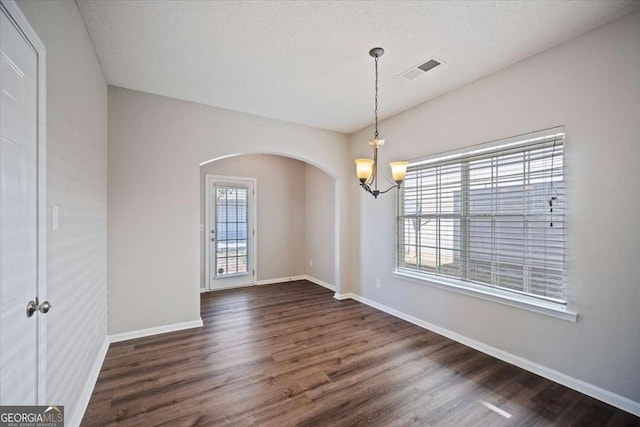 3223 Tallon Ln SW, Atlanta, GA 30311 - unfurnished room featuring a chandelier, arched walkways, dark wood-type flooring, and baseboards
