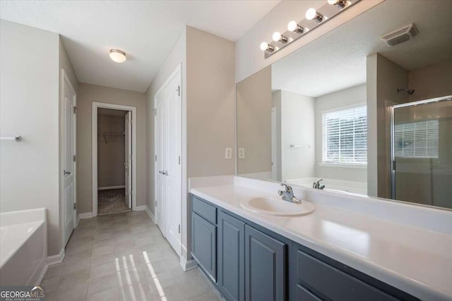 3223 Tallon Ln SW, Atlanta, GA 30311 - full bathroom featuring a bath, a stall shower, vanity, a walk in closet, and baseboards