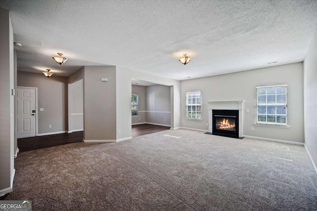 3223 Tallon Ln SW, Atlanta, GA 30311 - unfurnished living room featuring carpet, a textured ceiling, baseboards, and a fireplace with flush hearth
