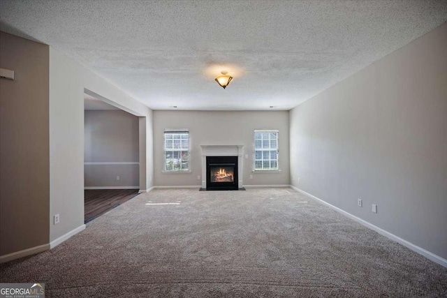 3223 Tallon Ln SW, Atlanta, GA 30311 - unfurnished living room featuring carpet floors, baseboards, a fireplace with flush hearth, and a textured ceiling