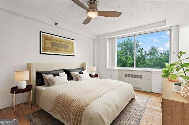 2479 Peachtree Rd NE Unit 305, Atlanta, GA 30305 - bedroom with radiator, a textured ceiling, light wood finished floors, and ceiling fan