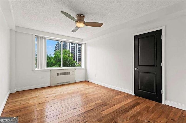 2479 Peachtree Rd NE Unit 305, Atlanta, GA 30305 - empty room with radiator, a textured ceiling, hardwood / wood-style floors, and ceiling fan