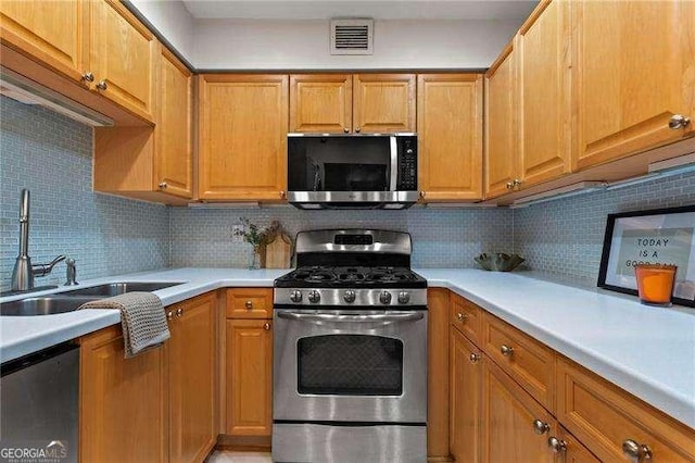 2479 Peachtree Rd NE Unit 305, Atlanta, GA 30305 - kitchen with appliances with stainless steel finishes, light countertops, decorative backsplash, and brown cabinetry