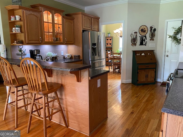 475 Harbour Shores Dr, Jackson, GA 30233 - kitchen with stainless steel fridge with ice dispenser, a peninsula, light wood finished floors, a breakfast bar area, and dark countertops