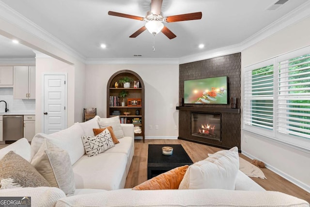 153 Witter Way, Woodstock, GA 30188 - living area with a fireplace, light wood finished floors, ceiling fan, crown molding, and recessed lighting