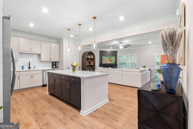153 Witter Way, Woodstock, GA 30188 - kitchen with ornamental molding, a center island, stainless steel appliances, light countertops, and light wood-style floors