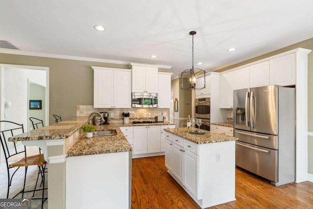 6695 Buckingham Cir, Cumming, GA 30040 - kitchen featuring stainless steel appliances, a peninsula, white cabinets, tasteful backsplash, and wood finished floors
