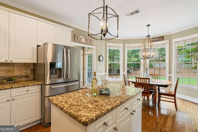 6695 Buckingham Cir, Cumming, GA 30040 - kitchen with a chandelier, stainless steel fridge, dark wood-type flooring, a kitchen island, and tasteful backsplash