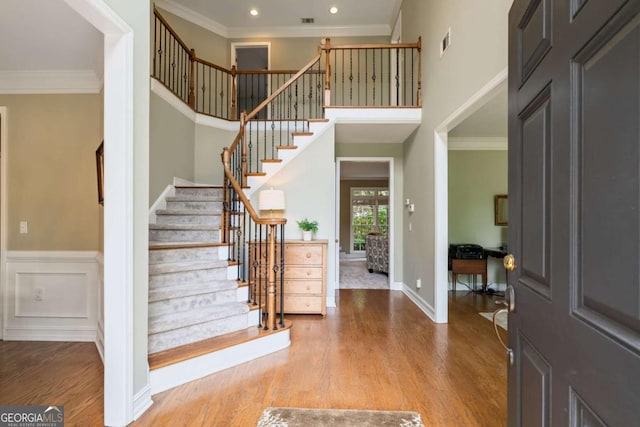 6695 Buckingham Cir, Cumming, GA 30040 - foyer entrance with wood finished floors, stairway, crown molding, recessed lighting, and a towering ceiling