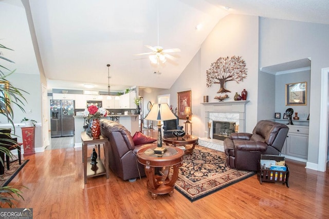 215 Fairway Ct, Newnan, GA 30265 - living area featuring a high end fireplace, light wood-type flooring, a ceiling fan, high vaulted ceiling, and baseboards