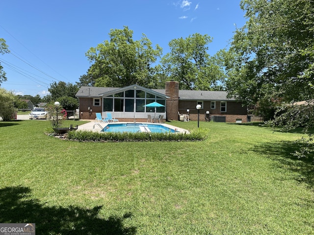 3788 Hartley Bridge Rd, Macon, GA 31216 - back of property featuring a sunroom, a chimney, a lawn, and an outdoor pool