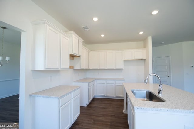 280 River Run Dr Unit 79, Dallas, GA 30132 - kitchen featuring a sink, dark wood finished floors, light stone countertops, white cabinetry, and a kitchen island with sink