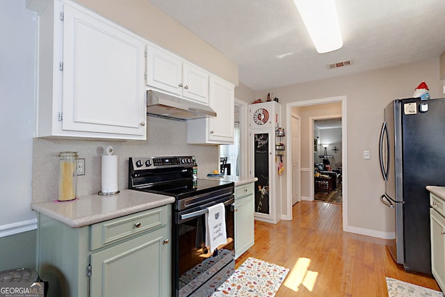 100 Huntcliff Ct, Lagrange, GA 30240 - kitchen featuring black / electric stove, under cabinet range hood, freestanding refrigerator, light wood finished floors, and light countertops