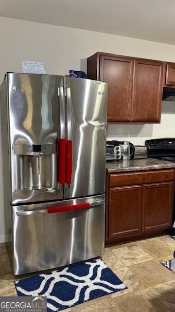 2080 Belmont Cir, Conyers, GA 30012 - kitchen with stainless steel fridge with ice dispenser, electric stove, dark countertops, range hood, and light stone finish floors