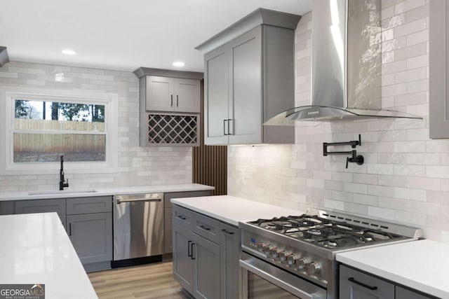 1120 Taliwa Trl NE, Marietta, GA 30068 - kitchen featuring wall chimney exhaust hood, appliances with stainless steel finishes, gray cabinets, tasteful backsplash, and light countertops