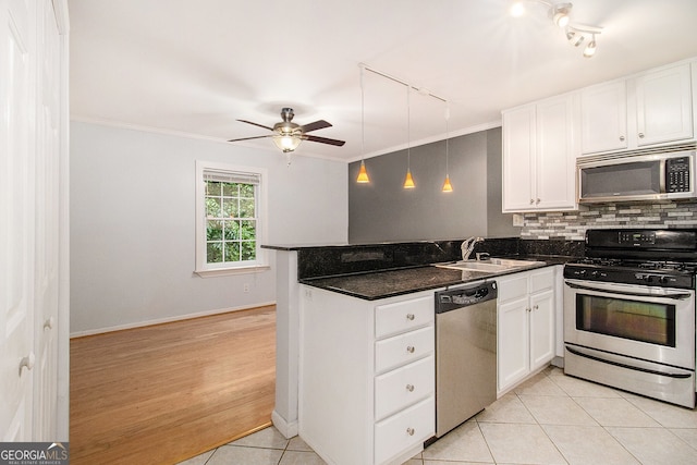 1445 Monroe Dr NE Unit F10, Atlanta, GA 30324 - kitchen with appliances with stainless steel finishes, rail lighting, a peninsula, white cabinets, and decorative backsplash