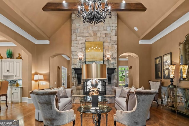 1031 Sugar Run, Greensboro, GA 30642 - living area with a chandelier, high vaulted ceiling, arched walkways, a stone fireplace, and wood finished floors